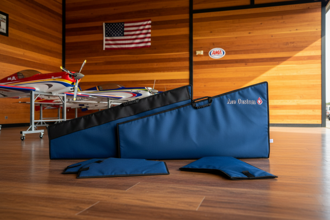 Ace Customs blue RC aerobatic wing bag set displayed in a wood-paneled hangar with an RC aerobatic plane, American flag, and AMA sign on the wall